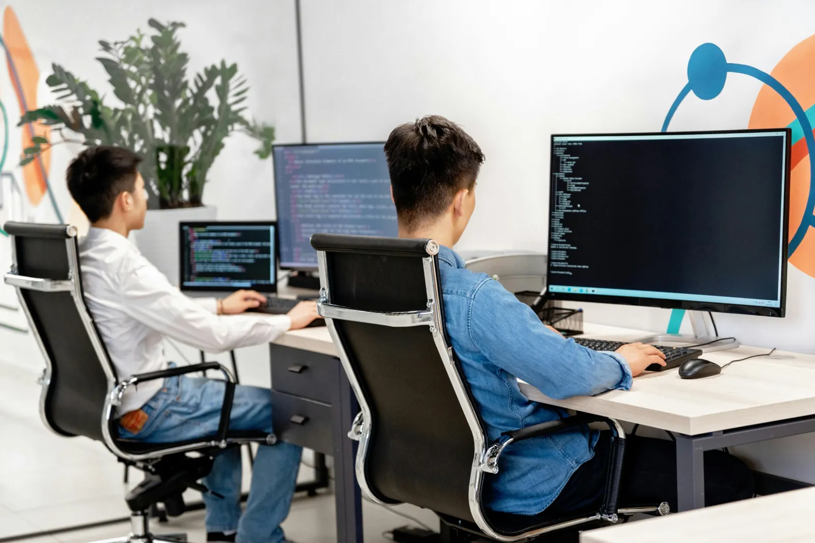 Developers writing code at a shared desk